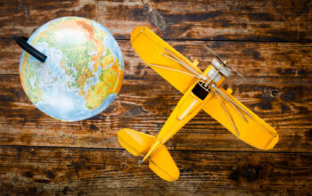concept - time to travel plane, globe on wooden table
